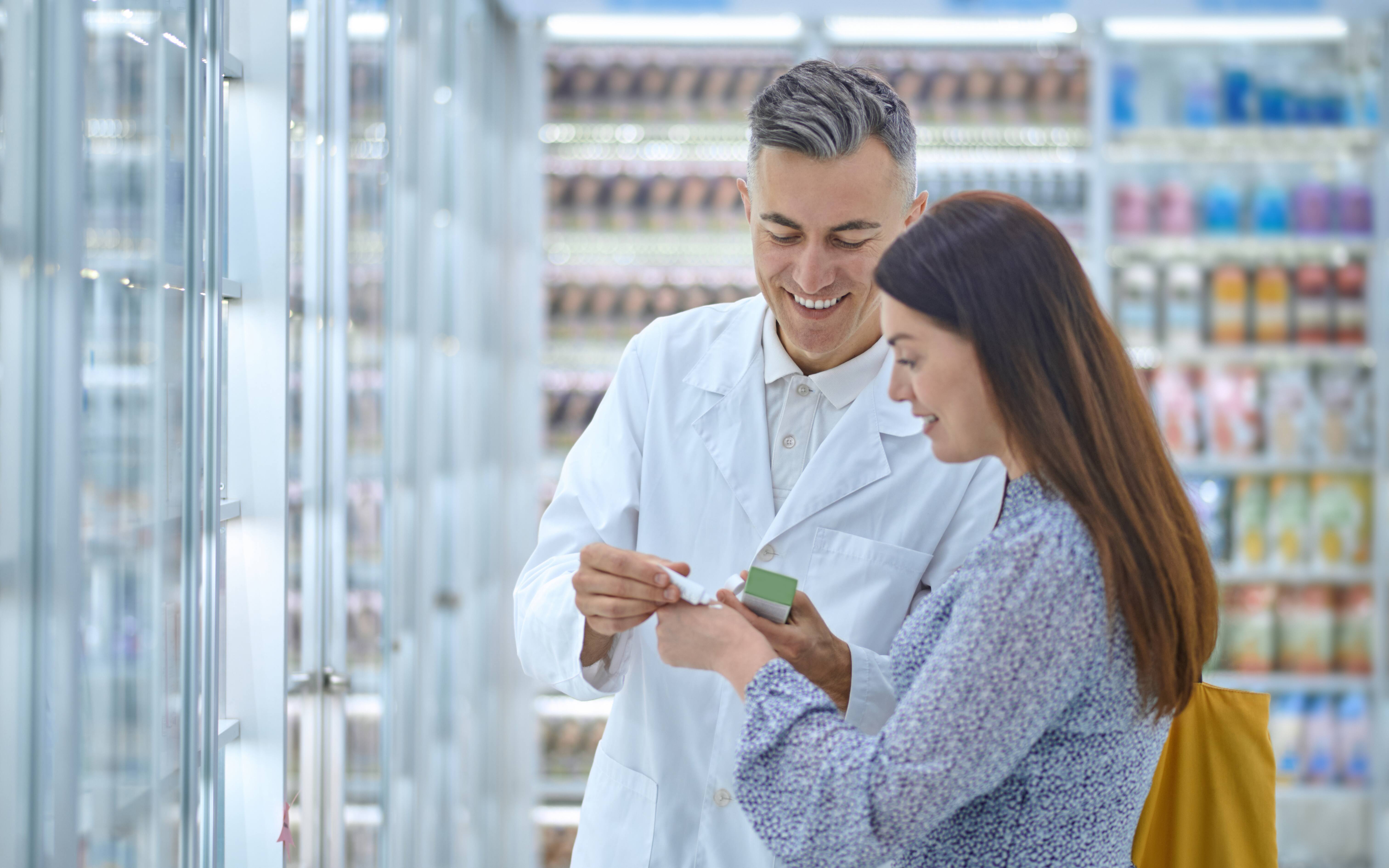 Male pharmacist talking with patient