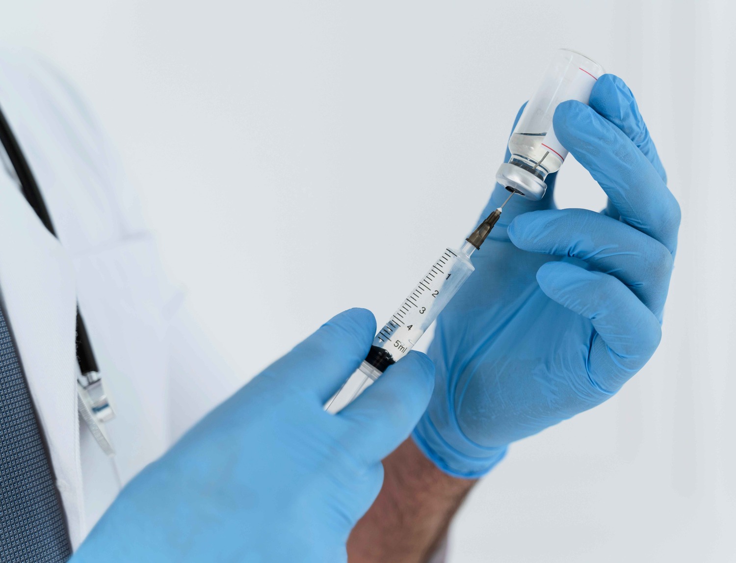 Hands preparing a syringe for a vaccine application